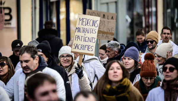 Des médecins manifestent avec des pancartes devant l'Agence régionale de santé (ARS) lors d'une marche de protestation qui a rassemblé près de 200 praticiens à Pau, en France, le 5 janvier 2026.