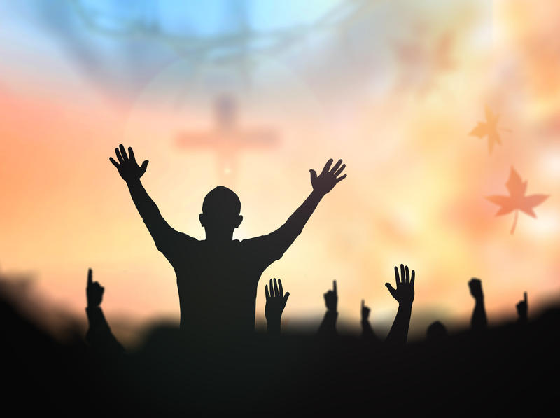 Silhouette people raising hands over blur crown of thorns and the cross on golden autumn sunset background. Thanksgiving, Christmas, Forgiveness, Mercy, Humble, Repentance, Reconcile, Glorify concept.