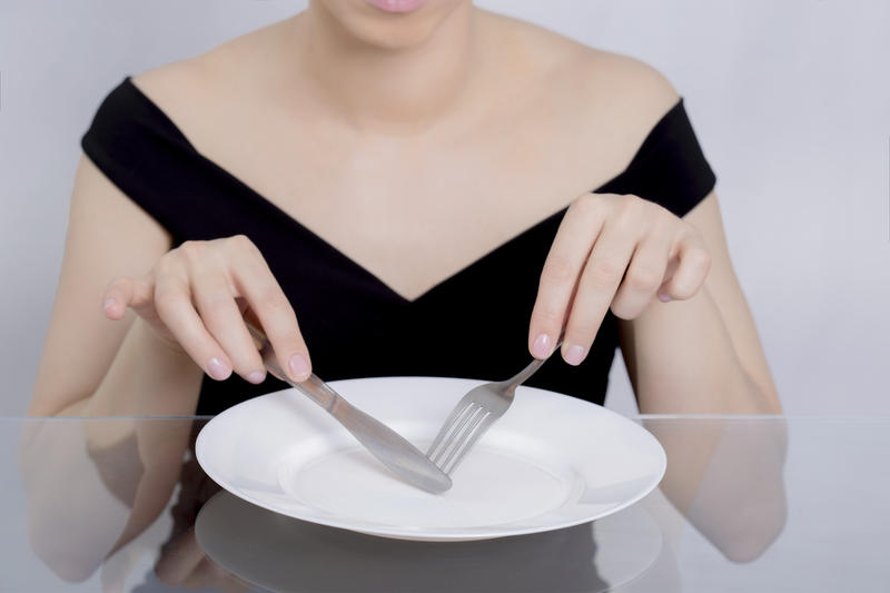 Femme devant une assiette vide