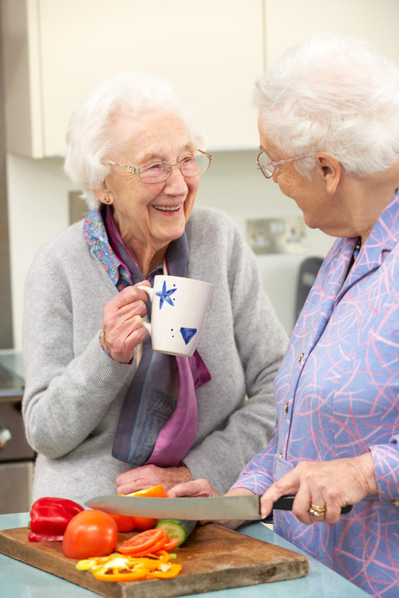 Senior women preparing meal together-shutterstock_99252008-Monkey Business Images-AI
