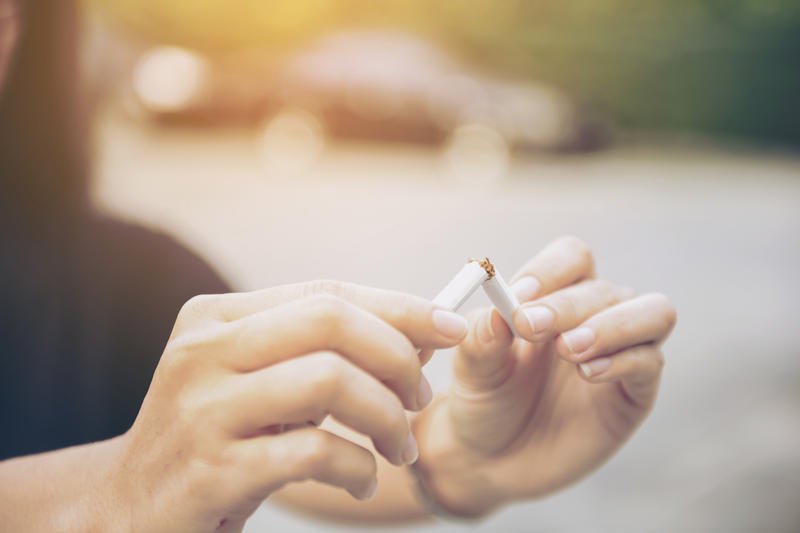 FEMME QUI CASSE EN DEUX UNE CIGARETTE