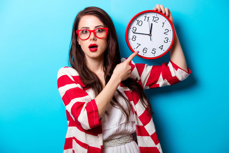FEMME TENANT UNE HORLOGE