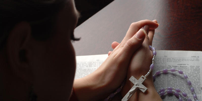 web-woman-praying-rosary-mehmet-alci-shutterstock_10641835