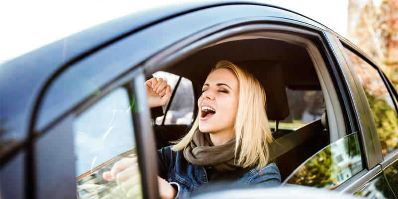 FEMME CHANTANT DANS SA VOITURE