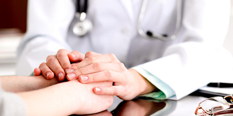 DOCTOR HOLDING PATIENTS HANDS
