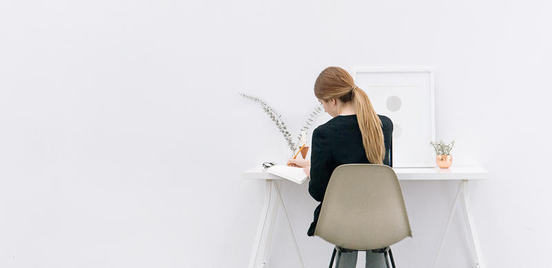 JEUNE FEMME DEVANT UN BUREAU