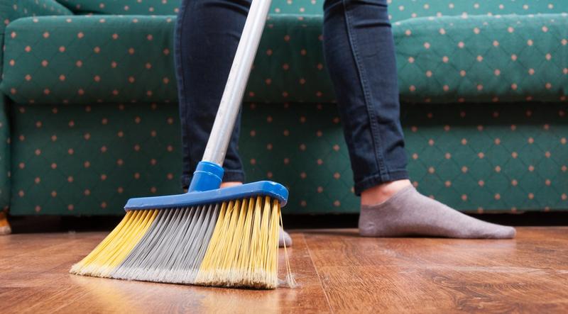 Woman sweeping wooden floor