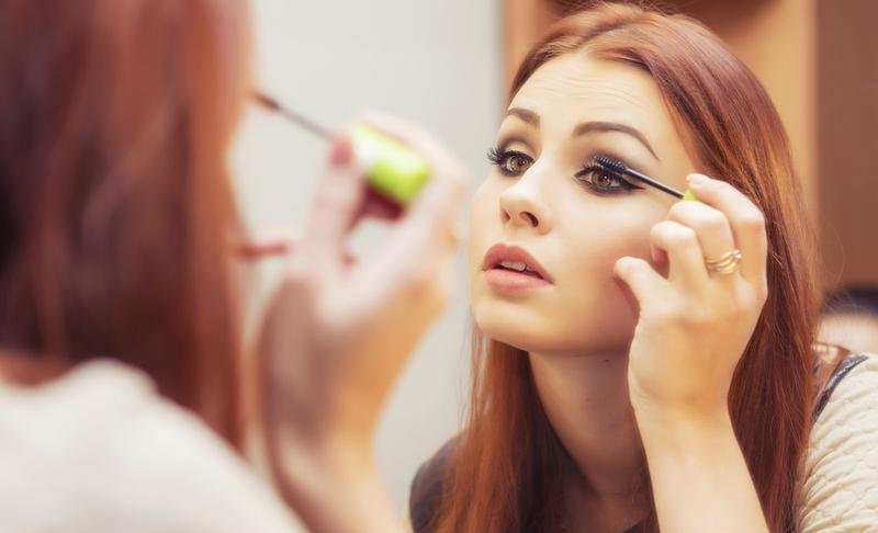 Woman putting mascara on