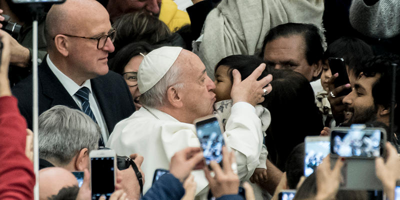 Pope Francis kisses a child