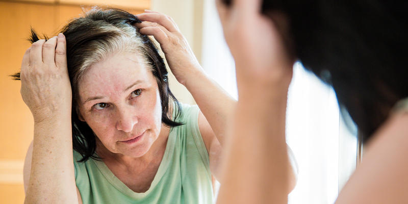 WOMAN LOOKING IN MIRROR