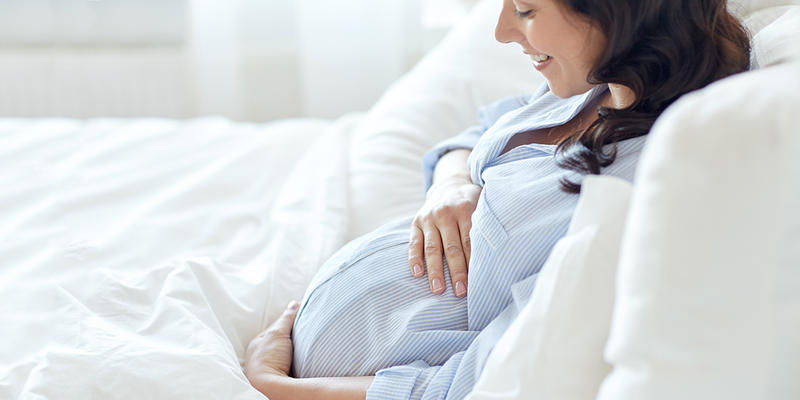 PREGNANT WOMAN LYING IN BED