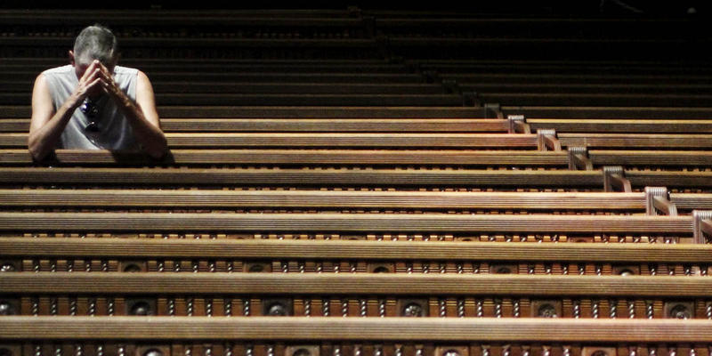MAN PRAYING IN PEW