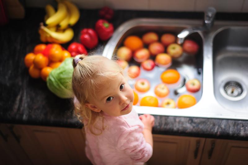 LITTLE GIRL WASHING FRUIT