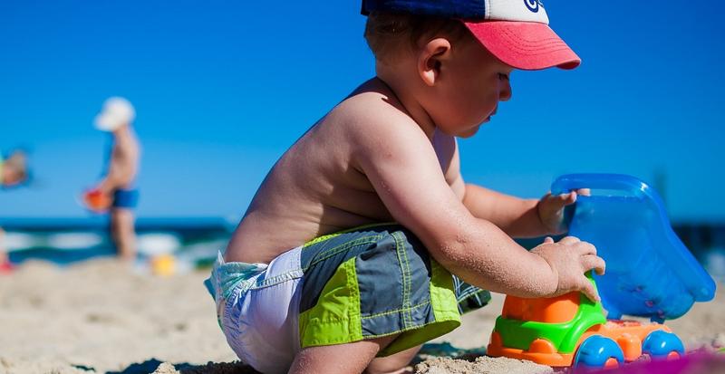 BOY PLAYING ON THE BEACH