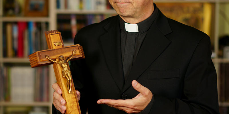 KSIĄDZ TRZYMA KRZYŻ