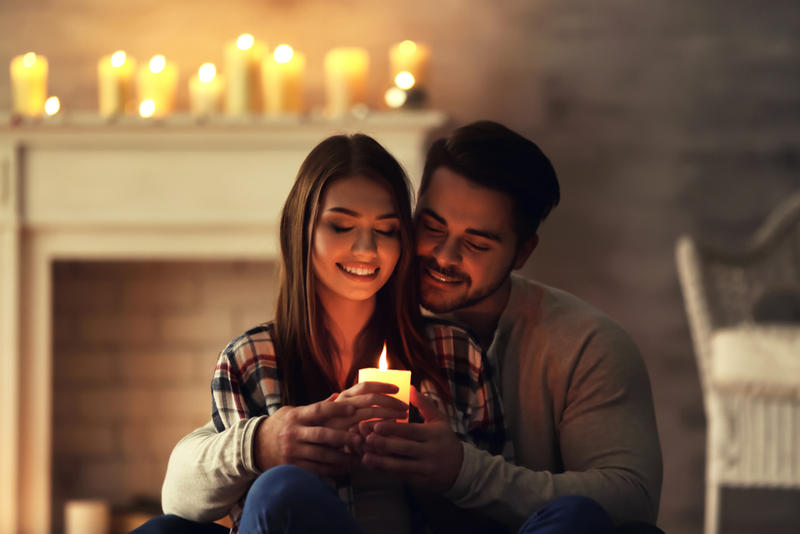 COUPLE AT HOME HOLDING CANDLE