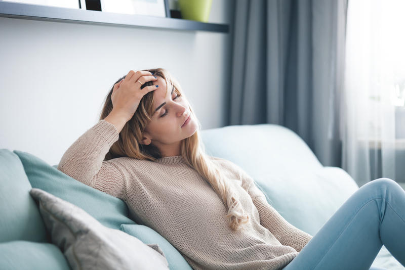 WOMAN SITTING ON COUCH