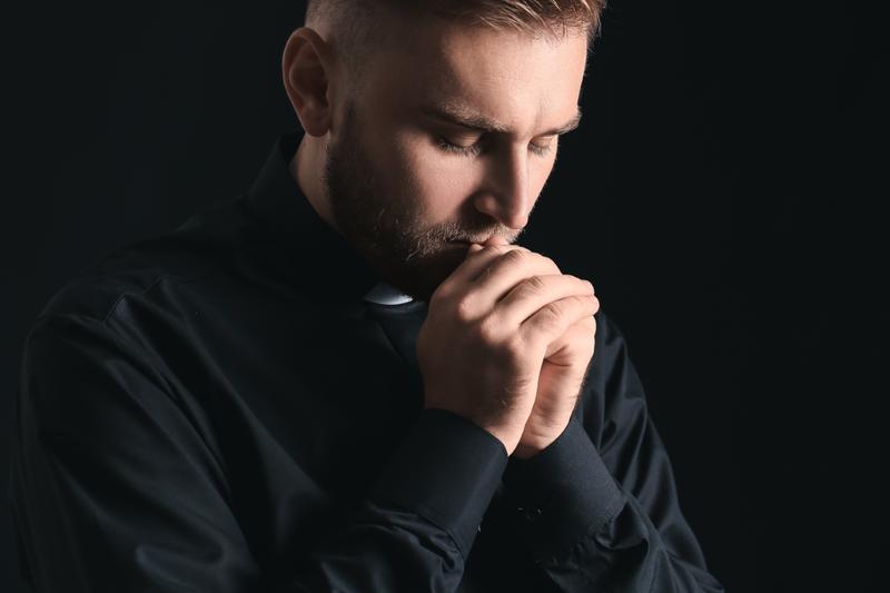 ksiądz w koloratce podczas modlitwy