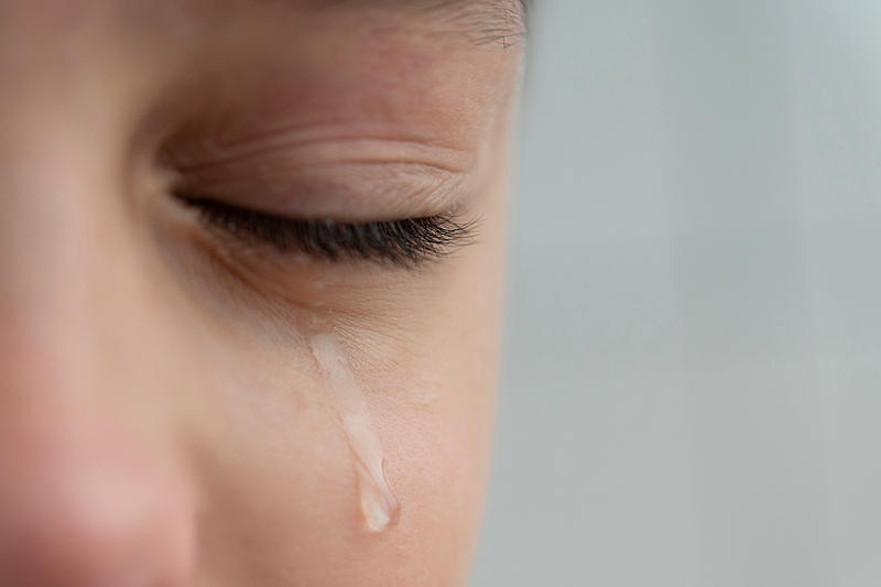 Close up image of teardrop rolls down the boys cheek his eyes are closed he is upset and crying Sad unhappy emotions of child