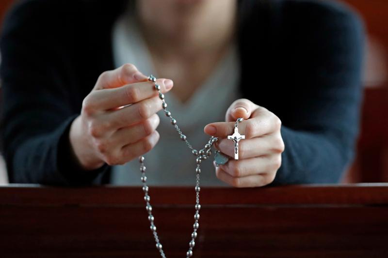 mujer rezando el rosario